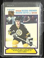 Front of the hockey trading card featuring Ray Bourque in Bruins uniform with 'Record Breaker' text