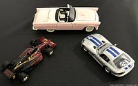 Three diecast car models shown together: Pink 1955 Ford Thunderbird, Silver and blue 1997 Dodge Viper GTS, and red/black 1995 Indy Car