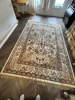 Carpet laid flat on herringbone floor, showing full design and fringed edge