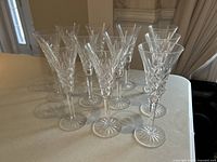 Eleven Waterford Ashbourne crystal champagne flutes arranged on a table, showing side perspective with some detail of cuts and design.