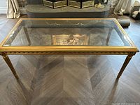 Top view of rectangular coffee table with removable glass top and gold frame.