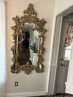 Full view of mirror hanging on wall showing frame and reflection