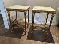 Pair of gold end tables shown side by side