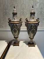 Front view of both urn vases side by side on marble surface
