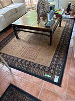 Full view of the olefin area rug under coffee table showing central pattern and border design.