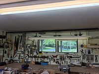 Full view of workshop wall with hand tools mounted above workbench