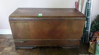 Front view of Red Seal antique cedar chest showing curved lid, finger-jointed corners, and bottom drawer base.