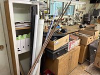 Overview of plumbing supplies stored in workshop area including pipe lengths and boxes of parts.