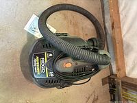 Top view of Rigid wet/dry vacuum showing vacuum hose wrapped around handle and power cord coiled on top.