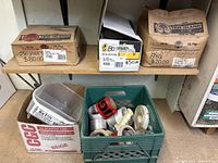 Shelf with three labeled boxes and a crate containing tape and roofing nails.