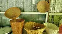 View of five assorted wicker baskets of various sizes and shapes displayed on shelf, showing overall lot contents.