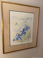 Frontal view of the mid-century modern watercolor painting of blue iris flowers, showing the artwork, beige matting, and gold metal frame.