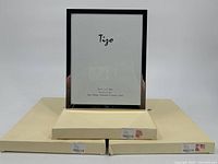 Three silver plated Tigo picture frames displayed with their original boxes stacked underneath. Frames measure 8x10 inches.