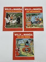 Three volumes of Willy and Wanda comic books shown together against a light background. Covers feature detailed cartoon scenes in red bordered covers.