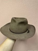 Front view of the Akubra Traveler Hat showing shape, material, and braided band with charms