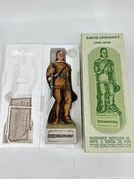 David Crockett whiskey bottle in foam packaging alongside original box and paperwork