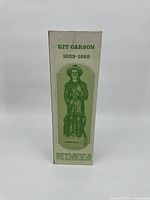 Box of Kit Carson whiskey bottle showing green illustration of the figurine and product details.