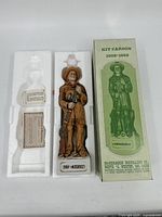 Full lot showing Kit Carson whiskey bottle standing upright in Styrofoam insert next to original cardboard box and certificate.