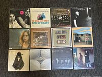 Photo of all 12 vinyl records arranged in two rows, showing album covers to identify artist and condition.