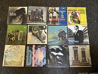 All 12 vinyl records arranged together showing varying album cover art and titles.