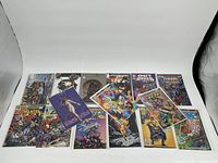 Photo showing 15 mixed publisher comic books arranged side by side, visible titles include Marian, Outbreed, Tokyo Storm Warning, and others.