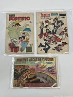 Lot of three Spanish comic books, clear plastic sleeves, visible wear and age.