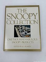 Front cover of The Snoopy Collection book showing title and image of Snoopy products on a boat.