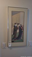 Framed Japanese style scroll art print with two figures in kimono in narrow silver frame