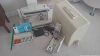 Full set showing Kenmore sewing machine, case, bobbin box, foot pedal, and manuals laid out for inventory
