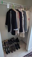 Photo of hanging women's coats and jackets in XS and Small sizes, mostly neutral colors including black, beige, off-white, and patterned gray.