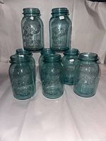 Eight Ball Blue Perfect Mason canning jars arranged on a white background, showing front embossed logo and text.