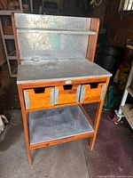 Front view of full potting bench showing aluminum top, backboard, drawers and lower shelf