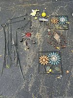 All items arranged on pavement showing complete assortment of metal lawn decor and chimes