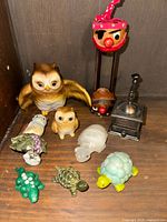 Full collection of miniature figurines including owls, turtles, bird, pirate head on stand, and small metal grinder