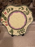 Full view of PartyLite cake candle serving plate with Strawberry Fields design showing scalloped edges and painted strawberries and leaves.