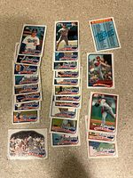 Top-down photo showing a spread of vintage baseball cards primarily featuring Los Angeles Dodgers players and some other teams. Cards are laid out on a beige surface showing front faces.