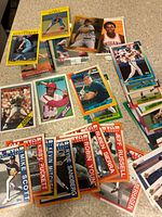 Photo shows a number of vintage baseball cards laid out on carpet, including players Kirby Puckett, Kevin Mitchell, Robin Yount, Jeff Russell, Mike Scott and others. Also visible are cards with All-Star Streaks branding and various team uniforms.