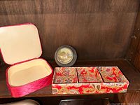 Pink satin fabric covered storage box with hinged lid, shown open revealing cream interior