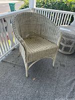 Vintage wicker chair without cushion on porch showing structure and weave pattern