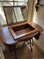 Vanity with mirror lifted up showing storage compartment inside the top.