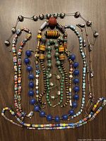 Overview of all necklaces showing diverse bead styles and colors arranged on wooden surface