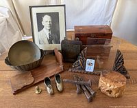 Photo of the lot with all brass and wood collectibles arranged on a table including bowls, ashtrays, letter holder, bookend, burl box, cedar chests, railway ties, and framed photograph.