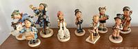 Front view showcasing all nine Hummel figurines arranged side by side, illustrating variety in poses and instruments.