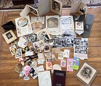 Wide view of the lot showcasing the assortment of photographs, letters, postcards, recipe pamphlets, yearbooks, greeting cards, advertisements, and folders arranged on a wooden floor.