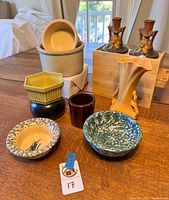All pottery items arranged on table including vase, candlesticks, bowls, planter, and crock; tag number 17 visible