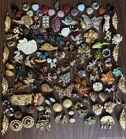 Full lot overview showing 80+ vintage brooches, pins, pendants, and earrings with animal, floral, leaf and novelty shapes in enamel, rhinestones, and gold/silver-tone finishes.