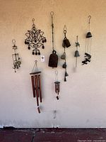 Photo of all eight metal wind chimes and the enameled bird plaque from a different angle for better view