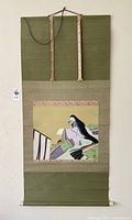 Full view of the Japanese rolled scroll showing the woman in kimono with fan mounted on green fabric.