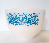 Side view of white milk glass bowl showing intricate blue floral Horizon pattern.