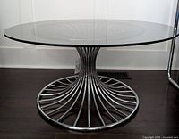 Side/front view of full coffee table showing glass top and chrome base